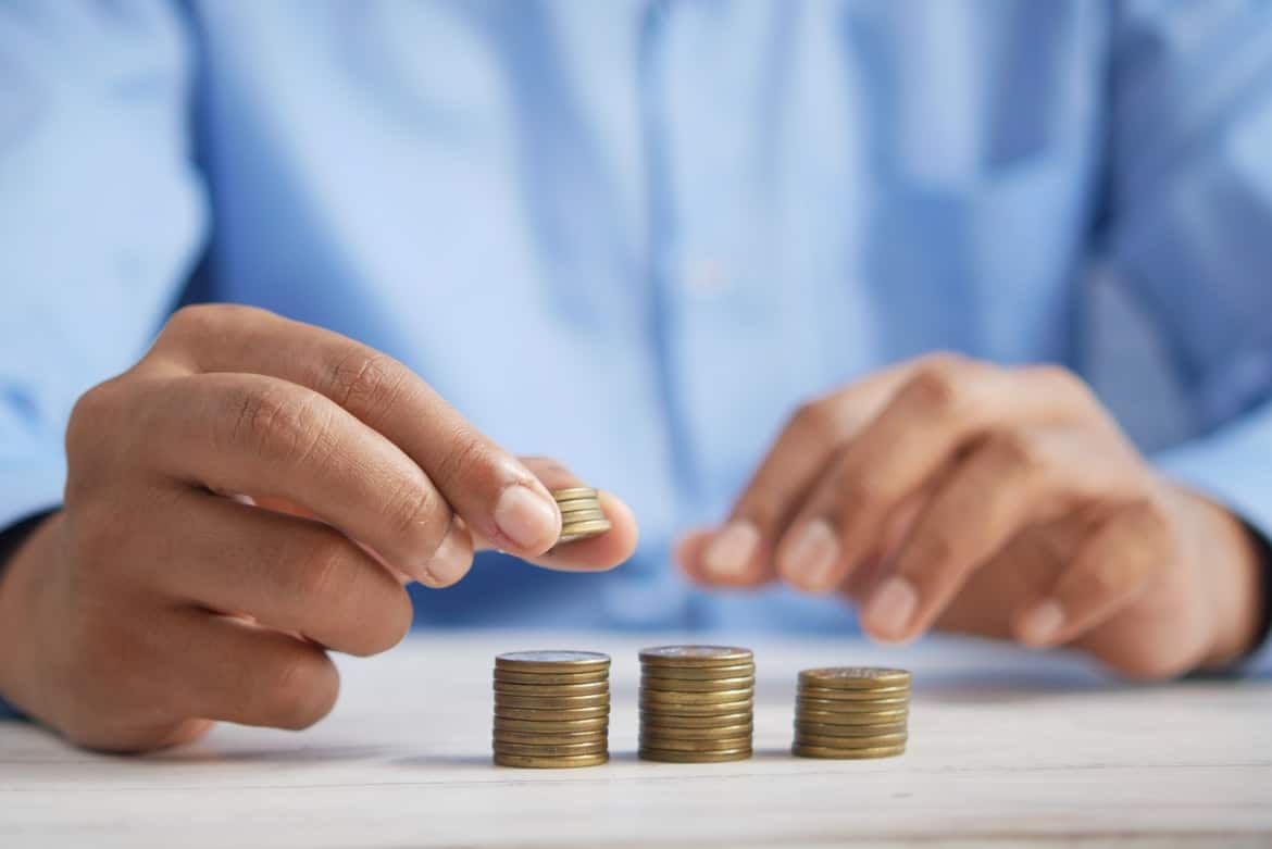 Man placing coins into different size piles