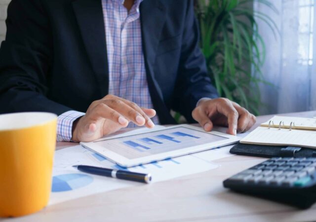 A man using a tablet and analysing financial charts