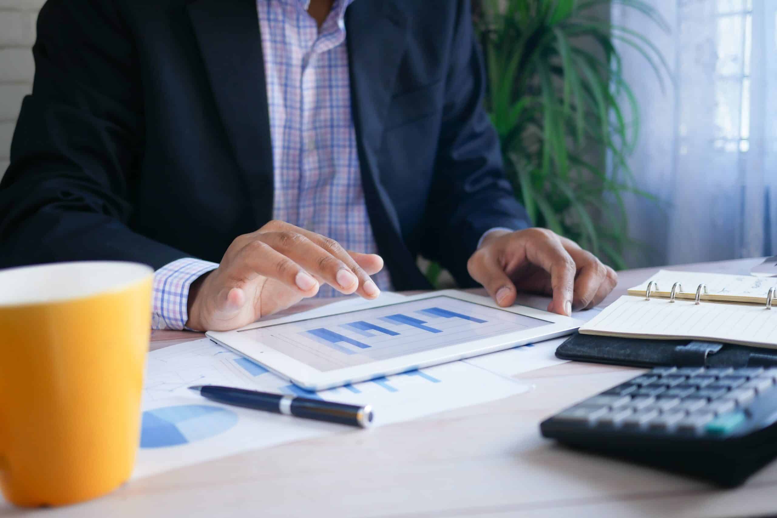 A man using a tablet and analysing financial charts